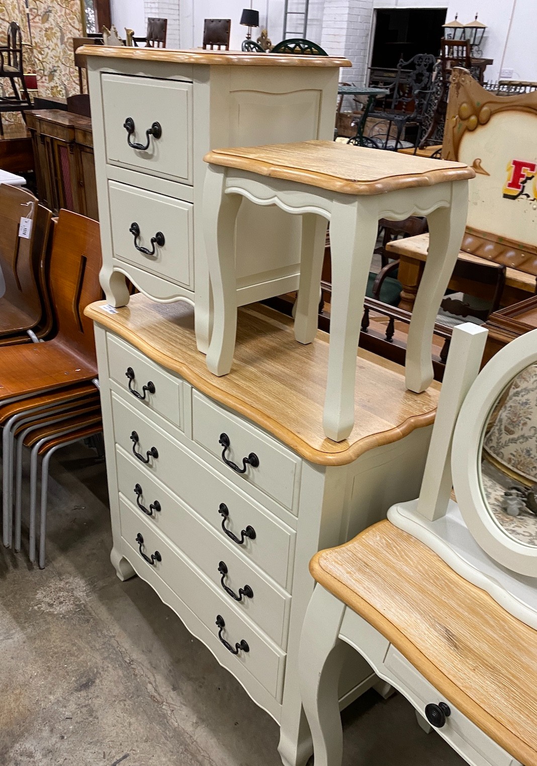 An oak and eau de nil painted wood six piecebedroom suite, from 'Oak Furniture Land' comprising a chest of drawers, dressing table and stool, a mirror and two bedside chests